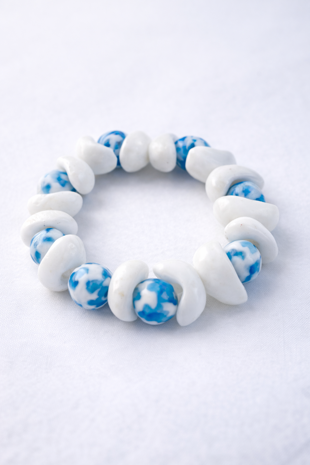 Handmade Krobo bead bracelet with white nd blue bead representing familywhite beads for parent ,blue center bead for child